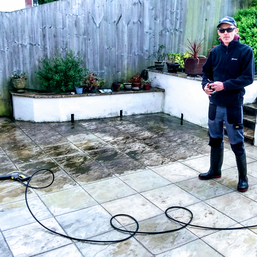 Ben jet washing a tiled patio after rainfall