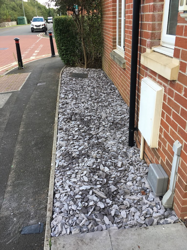 Tidy slate-chip border alongside a brick wall